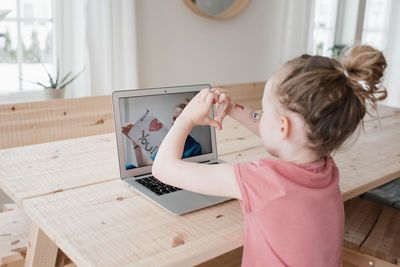 Young girl chatting with a nurse on video call saying i love you