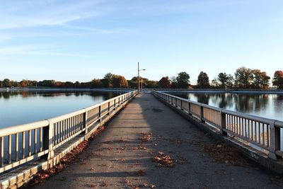 Bridge over river in city against sky