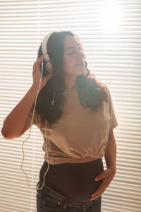 Midsection of woman standing against wall