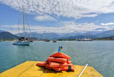 Sailboats moored on sea against sky