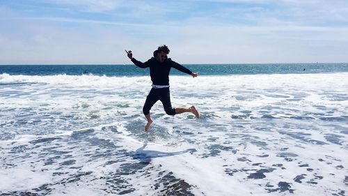 Silhouette of woman jumping on beach