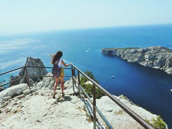 Rear view of woman looking at sea against sky