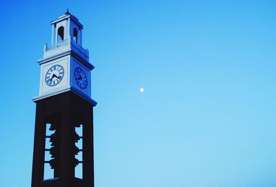 Low angle view of clock tower against blue sky