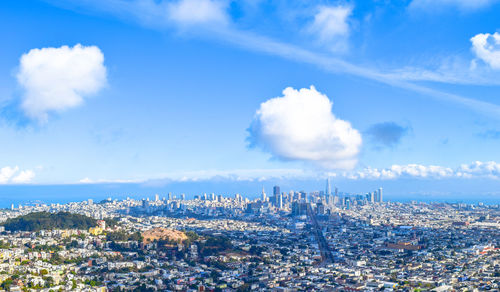 Aerial view of cityscape against cloudy sky