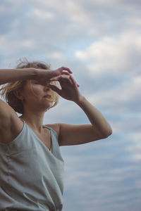 Midsection of woman wearing hat against sky