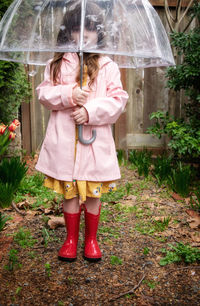 Woman with umbrella standing in rain during rainy season
