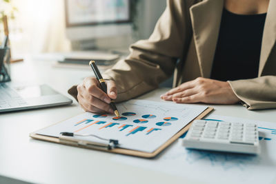 Midsection of businessman working on table