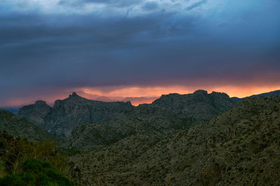 Dramatic sunset sky with monsoon rain over thimble peak in tucson, arizona.