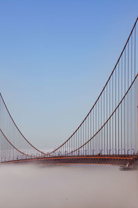 View of suspension bridge against clear blue sky