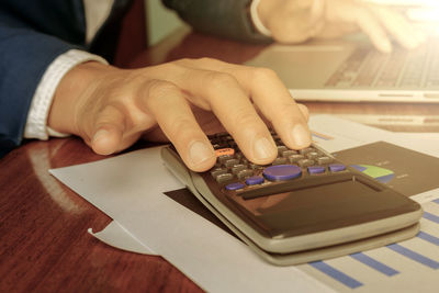 Close-up of person using smart phone on table