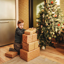 Boy wearing christmas tree at home