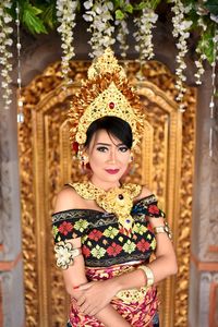 Portrait of young woman in traditional clothing standing at wedding ceremony