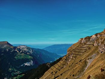 Scenic view of mountain range against blue sky