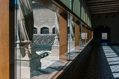 Empty corridor of building with light shining through windows, creating shadows