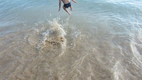 Low section of boy jumping in sea