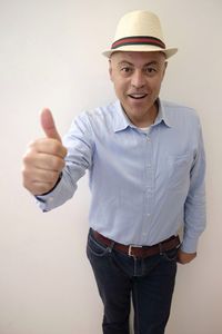 Portrait of smiling man gesturing against white background