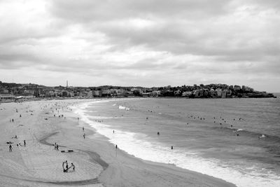 Scenic view of beach against cloudy sky