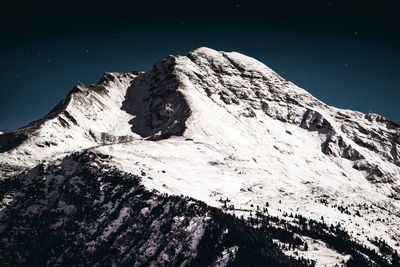 Scenic view of snowcapped mountains against sky at night