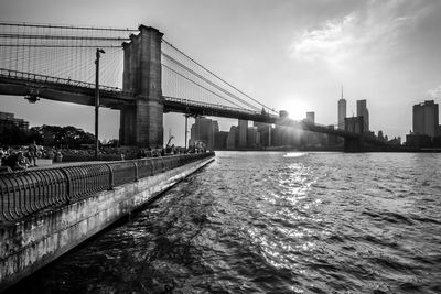 Brooklyn bridge over east river against sky in city