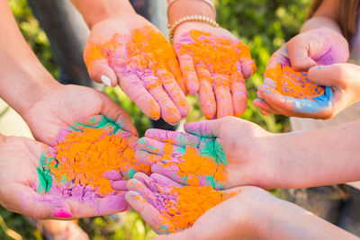 Close-up of hands holding multi colored human hand