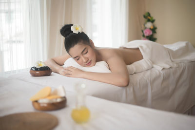 Young woman lying on massage table in spa