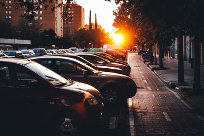 Cars on city street during sunset