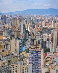 Aerial view of buildings in city against sky