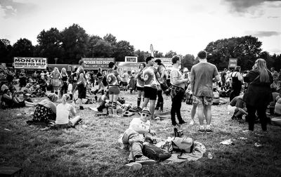 Side view of people sitting on field