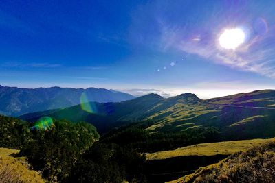 Scenic view of mountains against blue sky