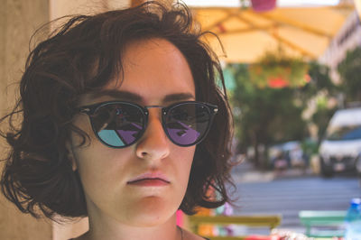 Close-up portrait of young woman wearing sunglasses