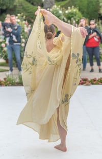 Midsection of woman with umbrella standing outdoors