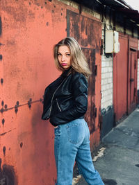 Portrait of woman standing against wall