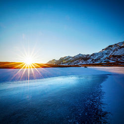 Scenic view of snowcapped mountains against blue sky during sunset