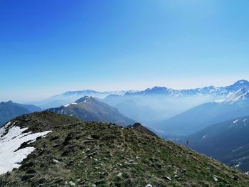 Scenic view of snowcapped mountains against clear blue sky