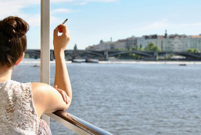 Rear view of woman looking at river in city