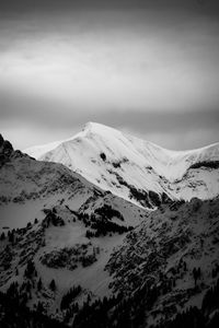 Scenic view of snowcapped mountains against cloudy sky