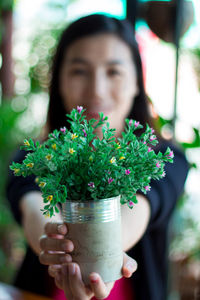 Midsection of woman holding potted plant