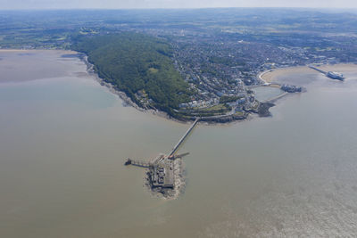 Aerial view of city by sea against sky