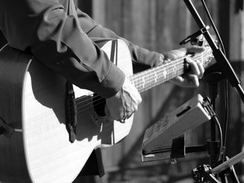 Midsection of man playing guitar