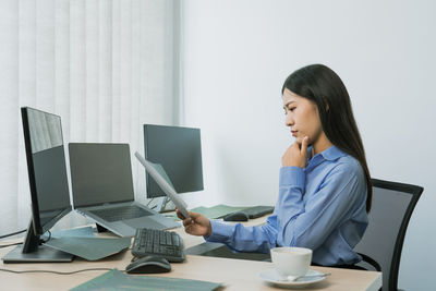 Woman using mobile phone while sitting on table