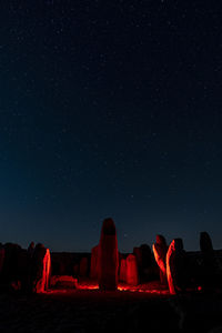 View of illuminated rock formation against sky at night