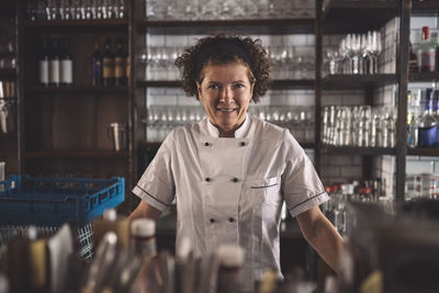 Portrait of smiling female chef in commercial kitchen