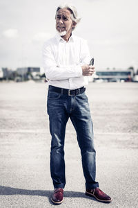 Full length portrait of a smiling young man standing outdoors