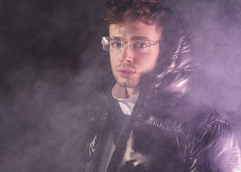 Portrait of young man against black background