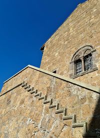 Low angle view of building against clear blue sky