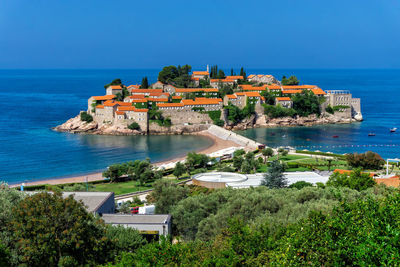 High angle view of buildings by sea against clear sky