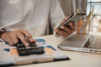 Midsection of man using laptop on table