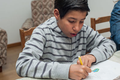 Rear view of boy looking at table