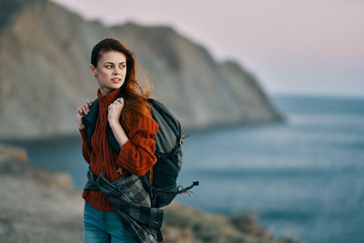 Portrait of teenage girl at beach against sky