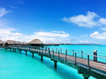 Pier on calm blue sea against sky